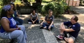 a group of teachers sitting on the ground in a circle