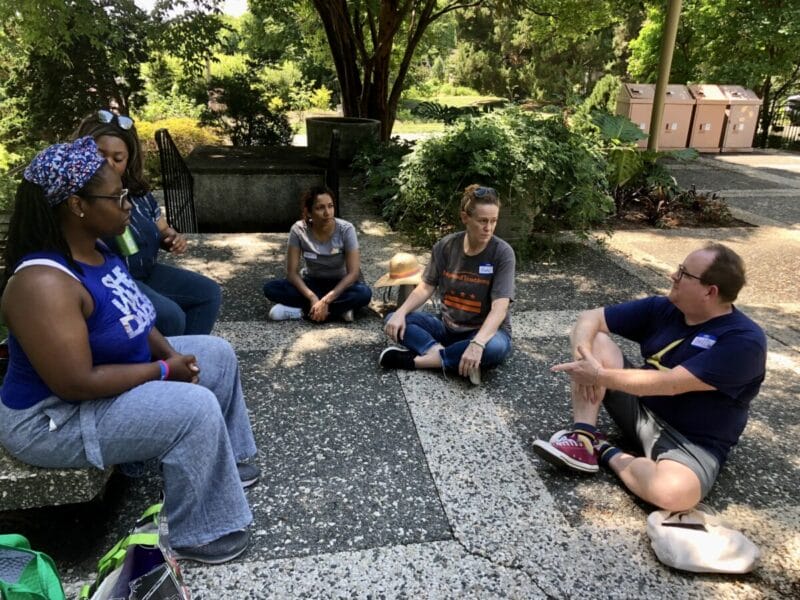 a group of teachers sitting on the ground in a circle